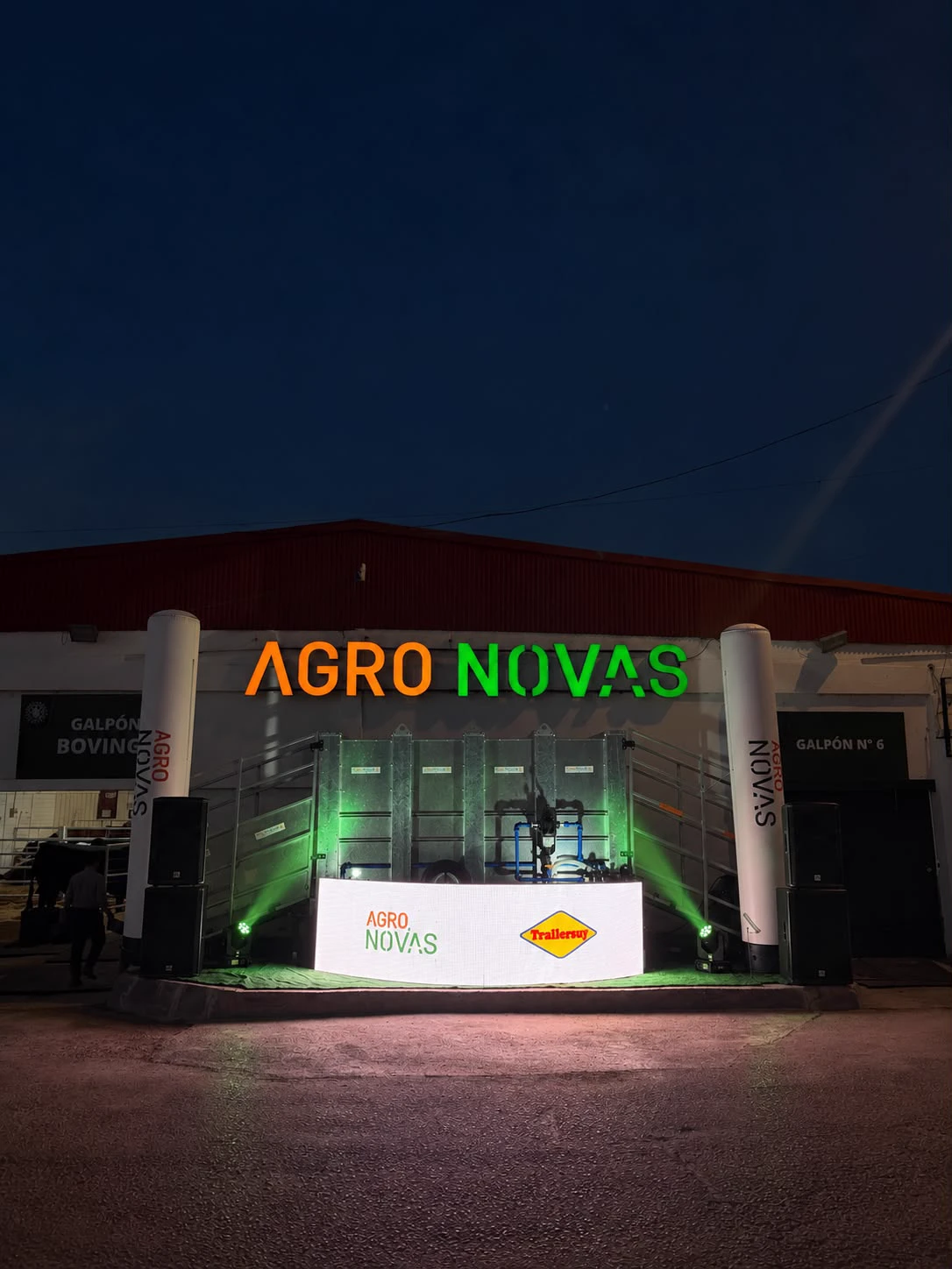 Stand de Agro Novas de noche con pantalla LED, columnas inflables, parlantes y luces